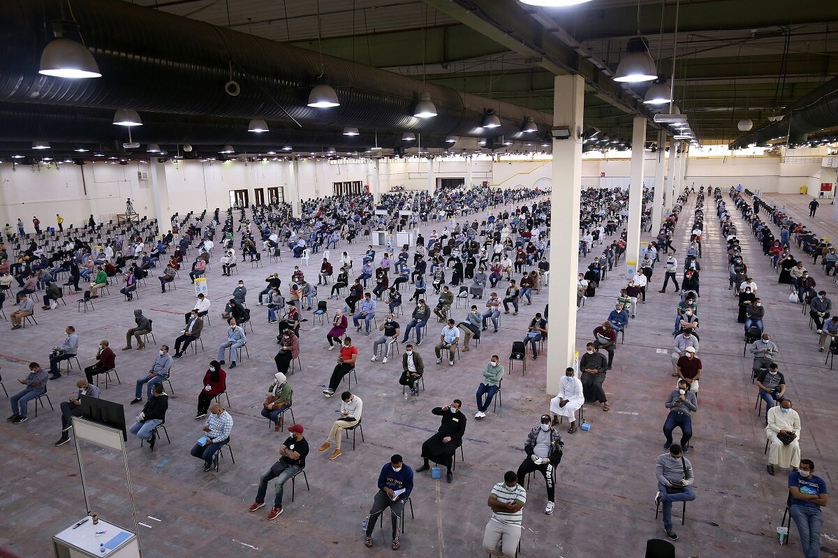 Kuveyt’te; Mısır, Suriye ve Lübnan'dan dönen yüzlerce göçmen, tarama alanında koronavirüs testi için sıra bekliyor.