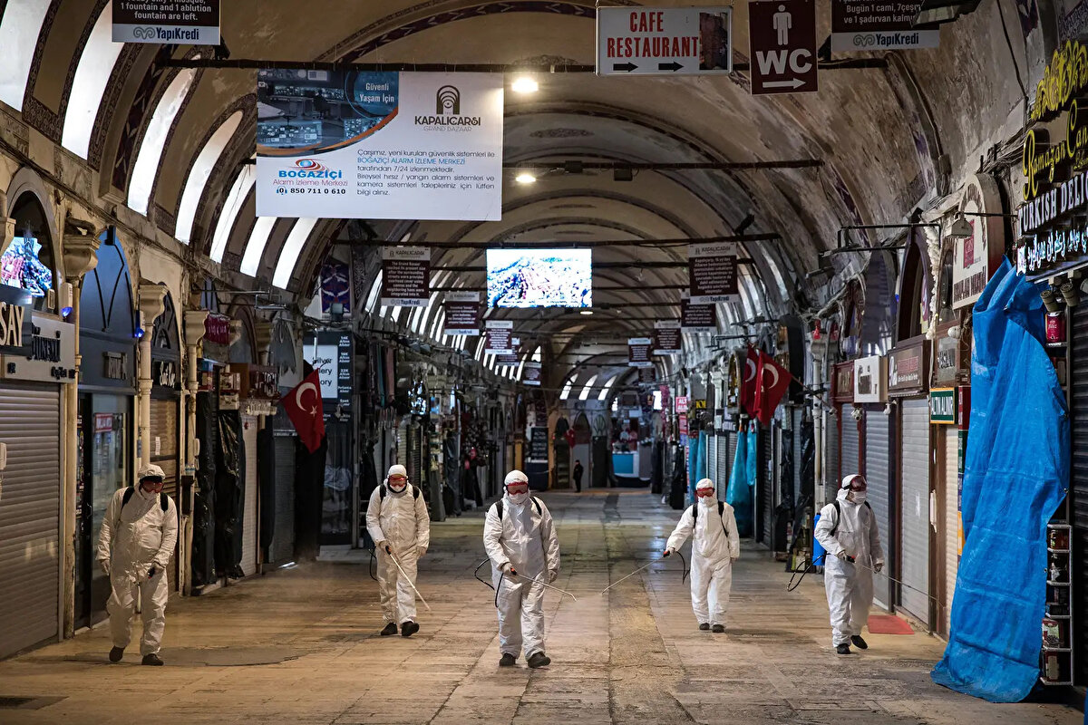 İstanbul, Türkiye- Koronavirüsün İstanbul'da yayılmasını önlemek için Kapalı Çarşı içindeki bir cadde boyunca dezenfektan püskürtüyor, 25 Mart.  