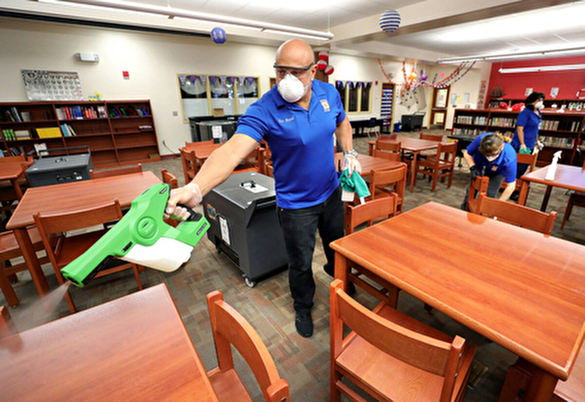 Orlando- Orange County Devlet Okullarından saklama çalışanları, 18 Mart'ta Wetherbee İlköğretim Okulu'nda derin temizlik için elektrostatik dezenfektan püskürtücü kullanıyor.  