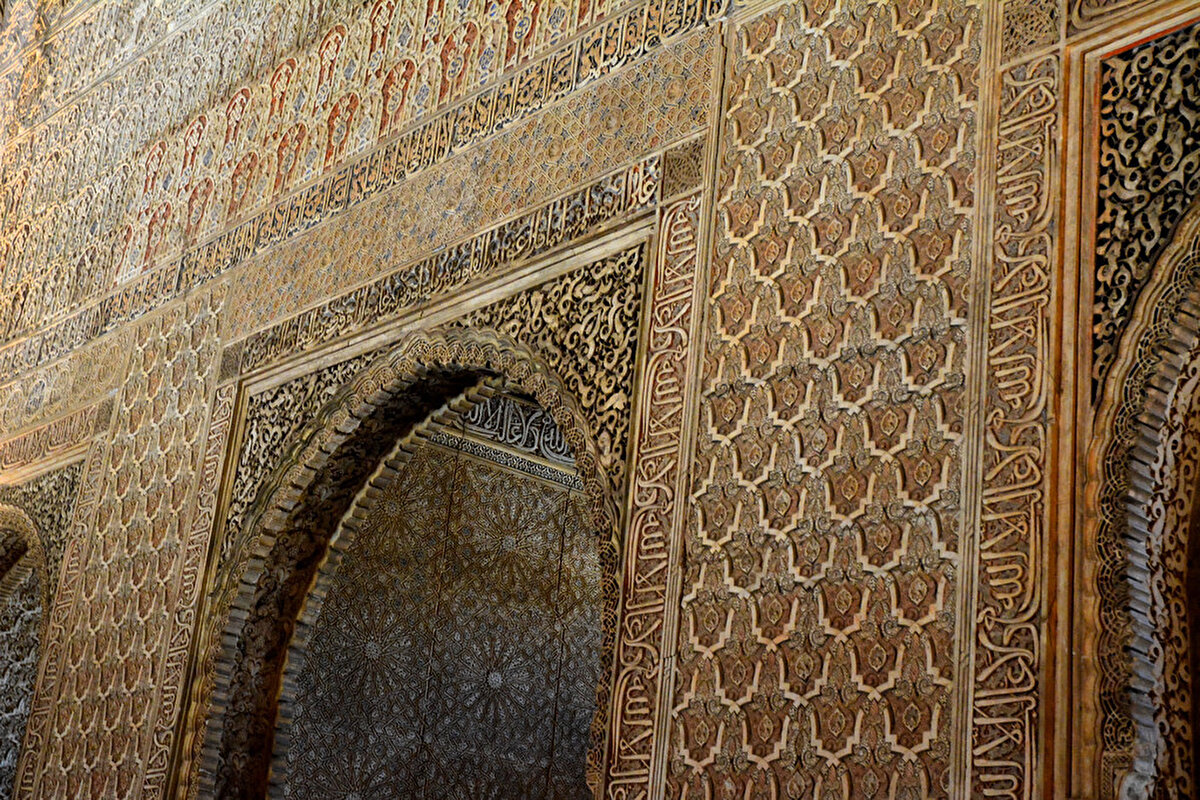 Kubbeli tavana uzanan beyaz alçı kaplama duvarlarında bitkisel ve geometrik desenler, aynı zamanda kuşaklar ve madalyonlar hâlinde tekrar eden “Ve lâ gâlibe illallah.” (Allah'tan başka galip yoktur ) hüsnühatları yer alır.