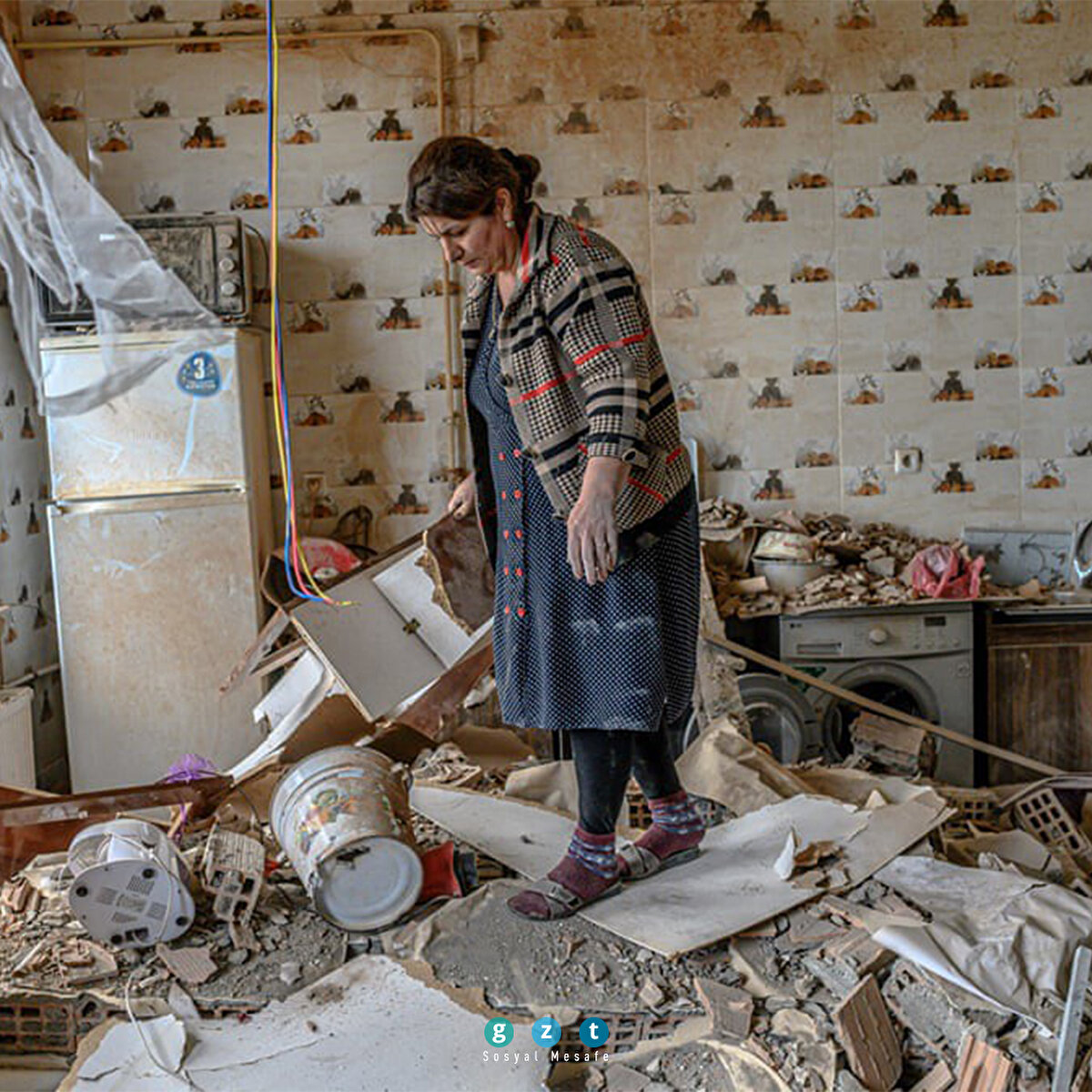 Ermenistan ile Azerbaycan arasındaki Dağlık Karabağ bölgesi üzerindeki askeri çatışmanın kurbanı olan Xatire Celilova, yıkılan dairesinin mutfağında yürüyor. (Bülent Kılıç/AFP)