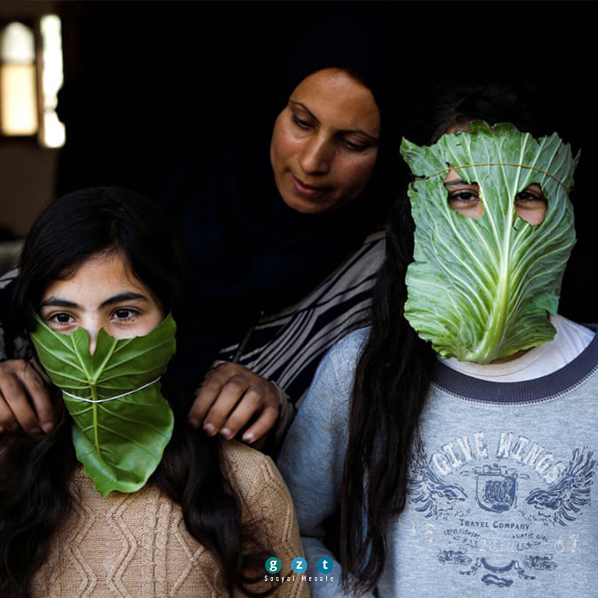 Filistinli bir palyaço, evlerinde oturmaktan sıkılan çocukları maskesiyle sokak sokak gezerek eğlendiriyor. (Mohammed Saber/EPA)