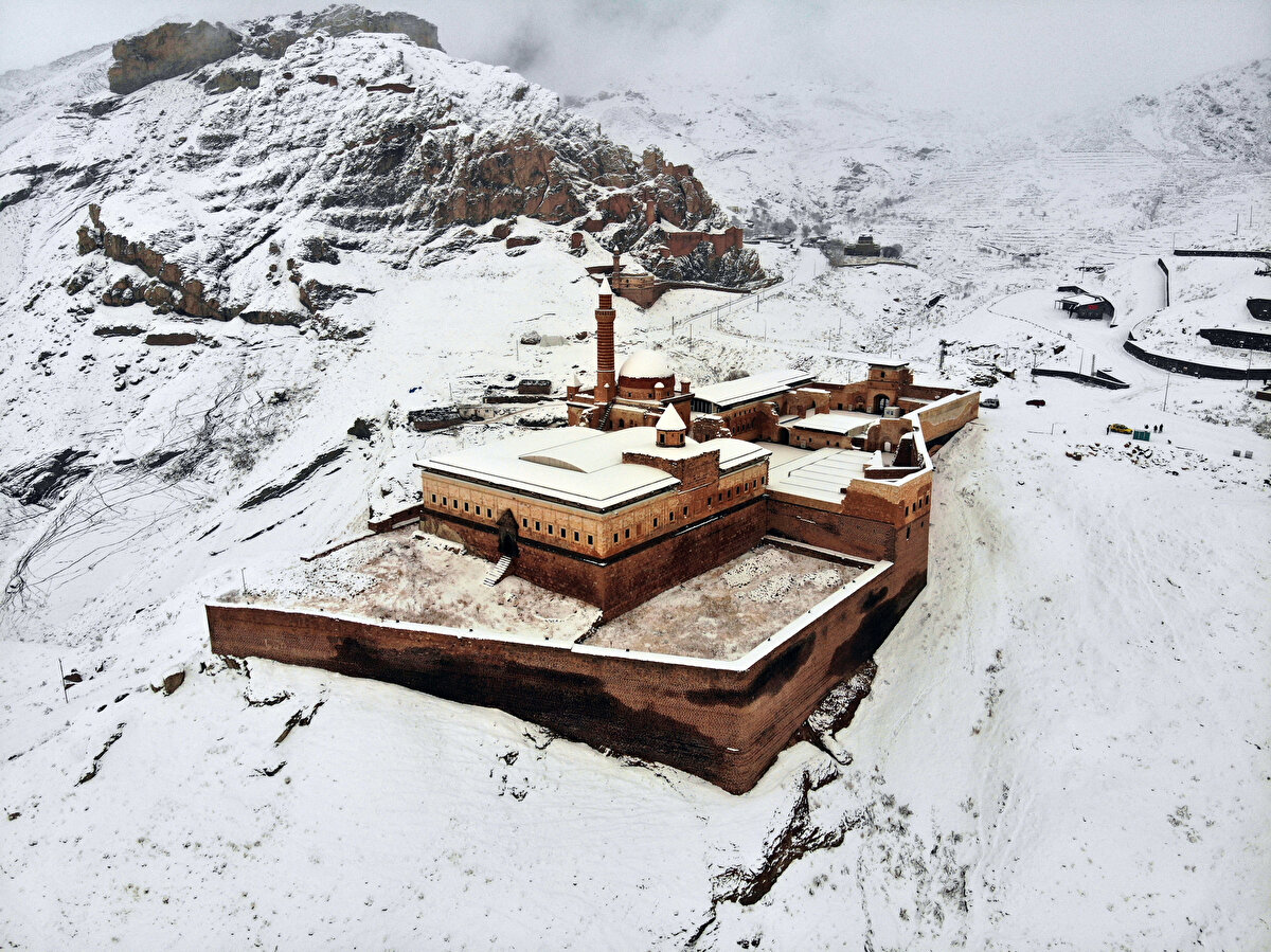 Doğu Anadolu Bölgesi'nin önemli turizm mekanları arasında yer alan Ağrı'nın Doğubayazıt ilçesindeki tarih İshak Paşa Sarayı ve çevresi kar yağışıyla beyaza büründü. "Medeniyetler geçidi" olarak adlandırılan bölgede 1900 rakımlı tepeye kurulu ve UNESCO Dünya Miras Geçici Listesi'nde de yer alan İshak Paşa Sarayı, konumunun yanı sıra sarp kayalıklar arasındaki bir tepede yer alan kartal yuvası görünümüyle de dikkati çekiyor.
