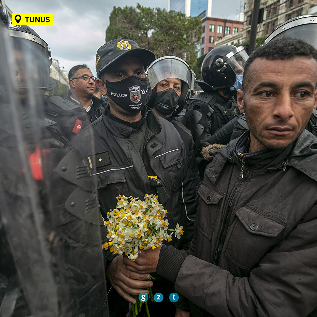 Tunus'ta COVID-19 tedbirlerine karşı bir haftadan bu yana devam eden gösterilerde gözaltına alınan kişilerin serbest bırakılması talebiyle başkent Tunus'un merkezindeki Habib Burgiba Caddesi'nde toplanan Tunuslular, gösteri düzenledi. Bir vatandaş, bölgede önlem alan polise çiçek verdi.