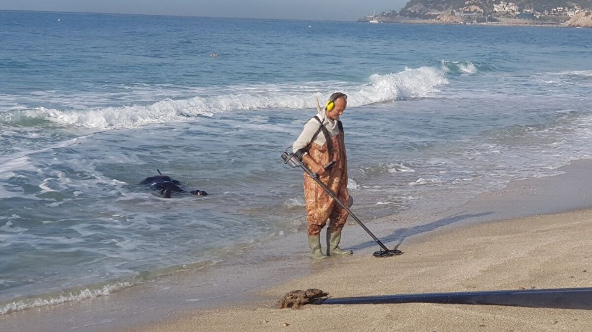 Elektronik cihazın çıkardığı sesleri kulaklıkla dinleyerek dedektörlerle değerli eşya arayanlar sahil bandını ve denizi kenarını taradı.  