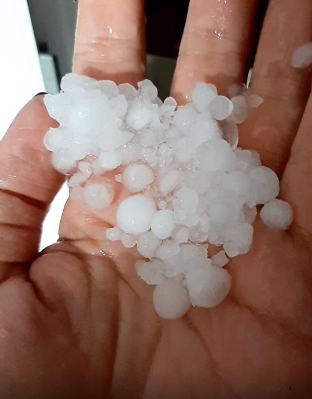 Çiğli ilçesinde biriken dolular kar yağışını andırdı. Vatandaşlar ev ve iş yerlerinin önünde biriken doluları küreklerle temizledi.