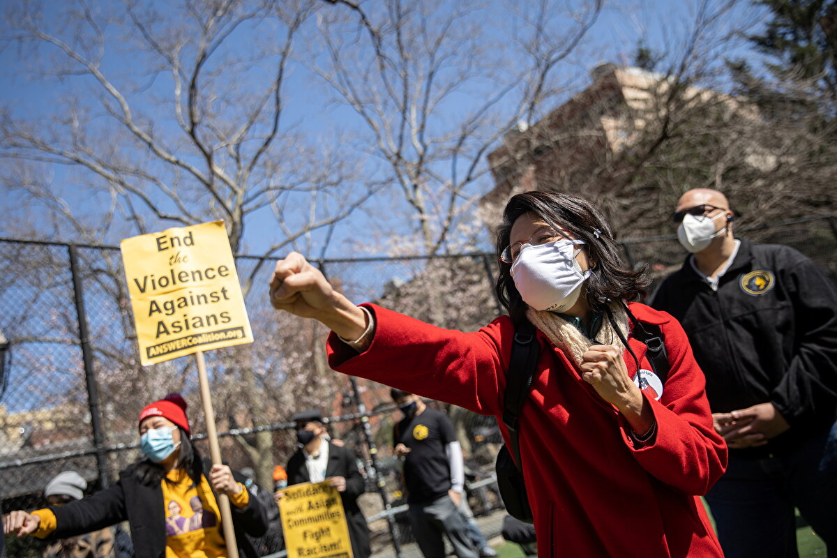 New York Belediye Meclisi Adayı Jenny Low 'kendini savunma' hareketleri yapıyor. Arkada görünen afişte, Asyalılara Karşı Şiddeti Sonlandır ifadesi yer alıyor.