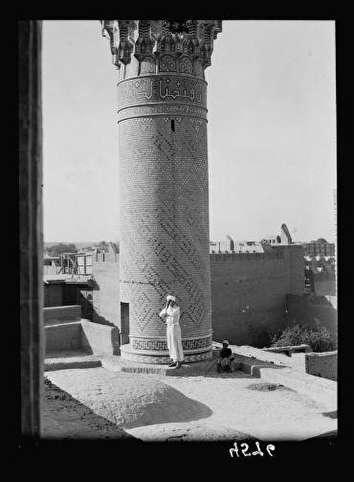 Haydar Han Camii’nde minarenin hemen yanında ezan okuyan bir müezzin, 1932. İlk hali Haydar Paşa tarafından inşa ettirilen cami, 1819-1827 yılları arasında Bağdat Valisi Davut Paşa tarafından restore ettirilmiş ve genişletilmiştir.