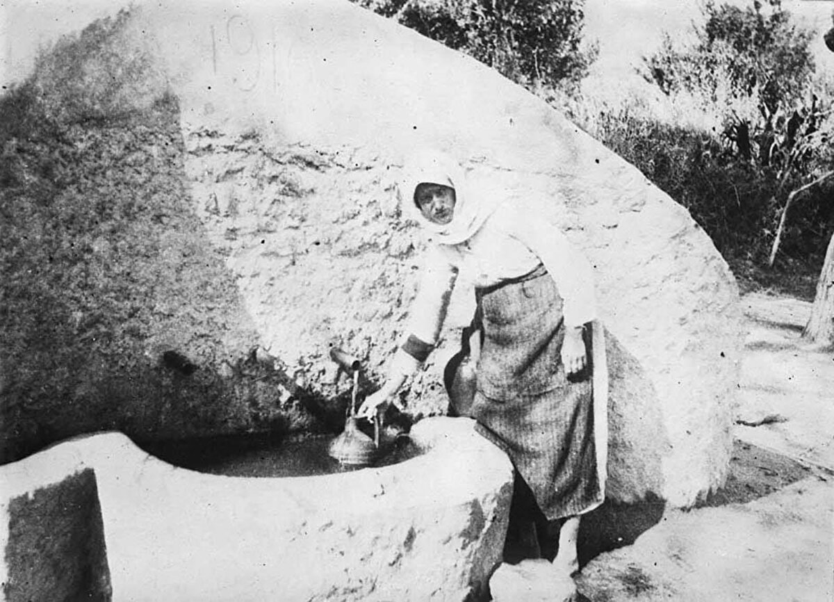 Evine götürmek için köy çeşmesinden su dolduran bir Türk kızı.