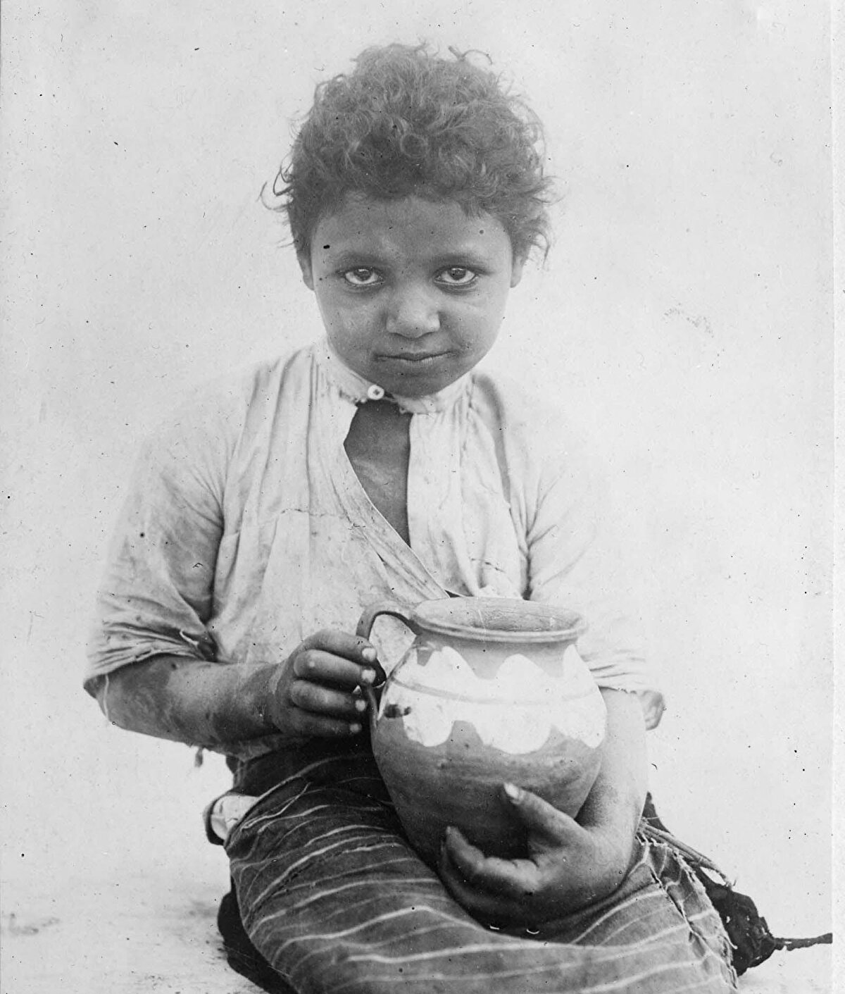 Balkanlar'da tipik bir çingene kızı: Tifüs gibi bulaşıcı hastalık dönemlerinde, çingeneler hastalıkla mücadeleyi göçebe yaşam tarzları nedeniyle zorlaştırıyordu. Fotoğrafa düşülen nota göre ise bu küçük kız çanak çömlek satarken fenalaşmış.