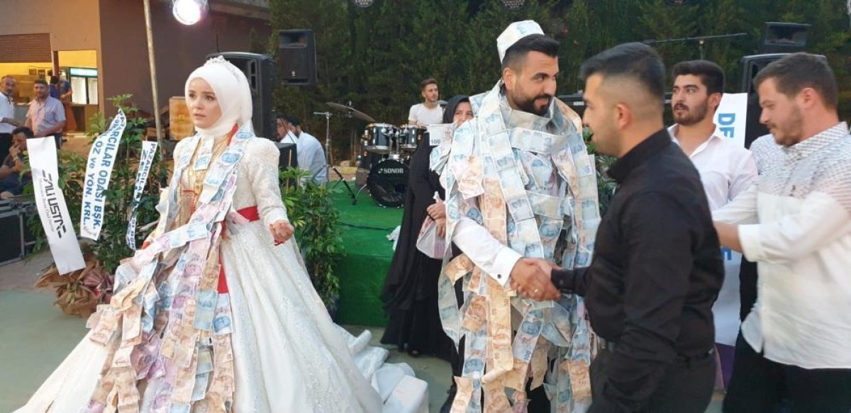 Damat ile gelini paraya boğan davetliler, damadı adeta para ağacına çevirdi.
Damadın arkadaşlarının 100 liralık banknotları rulo halinde takmaları dikkat çekti.Takıların içinden çeklerin çıkması ise sürpriz oldu.