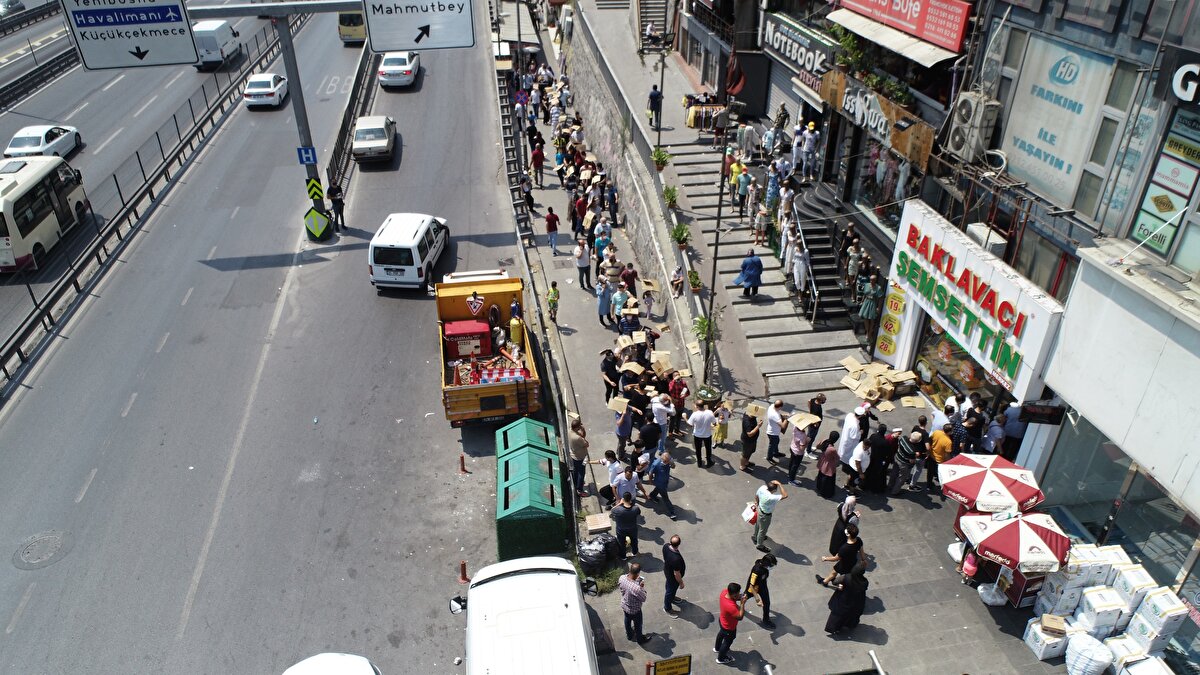 Bazıları sıcaktan daha az etkilenmek için karton parçalarıyla kendilerine gölge yaptı. Metrelerce uzayan baklava sırası havadan görüntülendi.