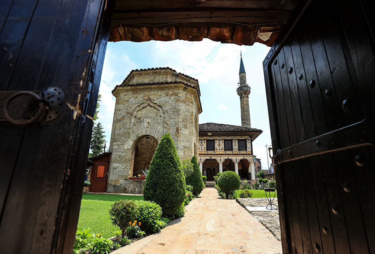 Alaca Camii'nin avlu kapısından bir görüntü. Avlusunda, Hurşide ve Mensure kız kardeşlerin türbelerinin de bulunduğu camii oldukça özenli bir bahçe düzenlemesine sahip.