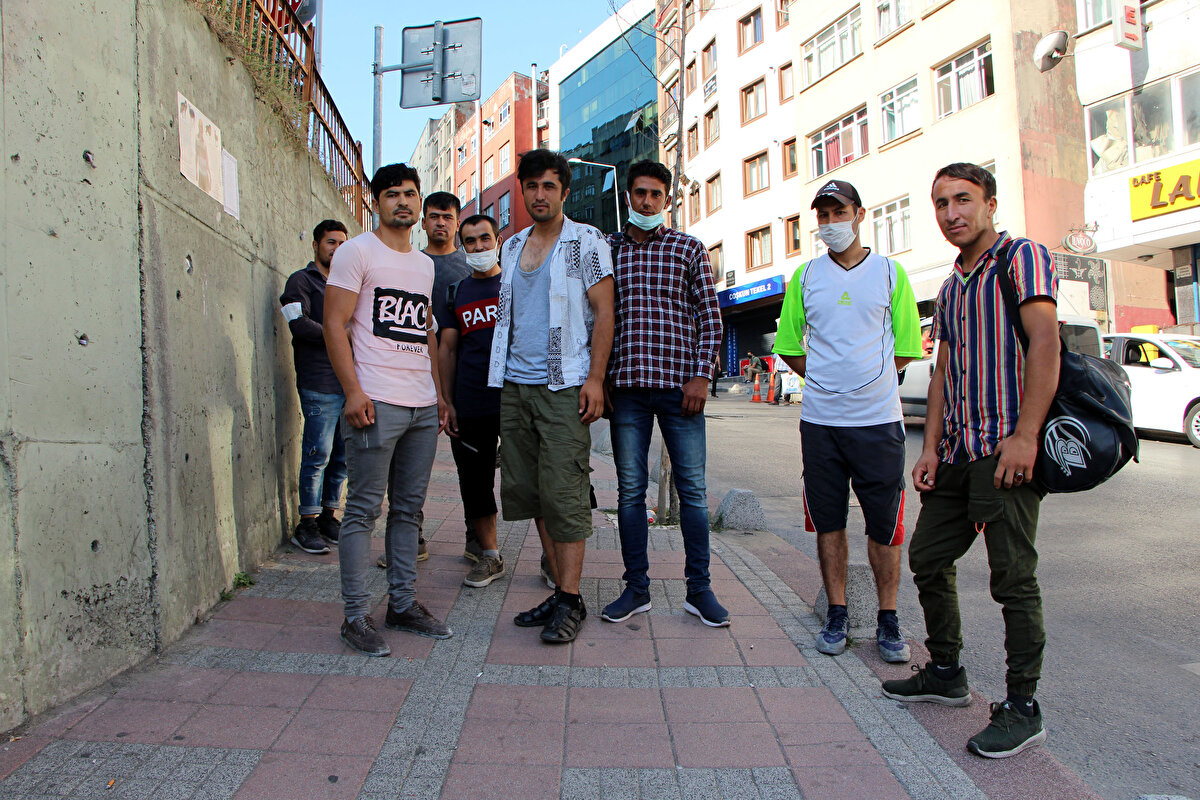 Kaçak göçmenlerin de aralarında yer aldığı grup, günlük bir işte çalışmak için kendilerini alacak araçların yolunu gözlüyor.
