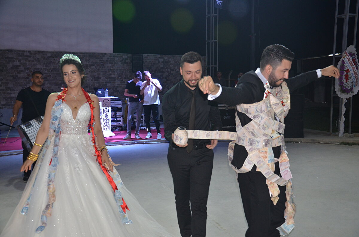 Damadın arkadaşları Şahin Madan ve Cihan Eroğlu, takı merasimi sırasında iğnelerle tutturdukları 5 liralık banknotları düğün hediyesi yaptı.  