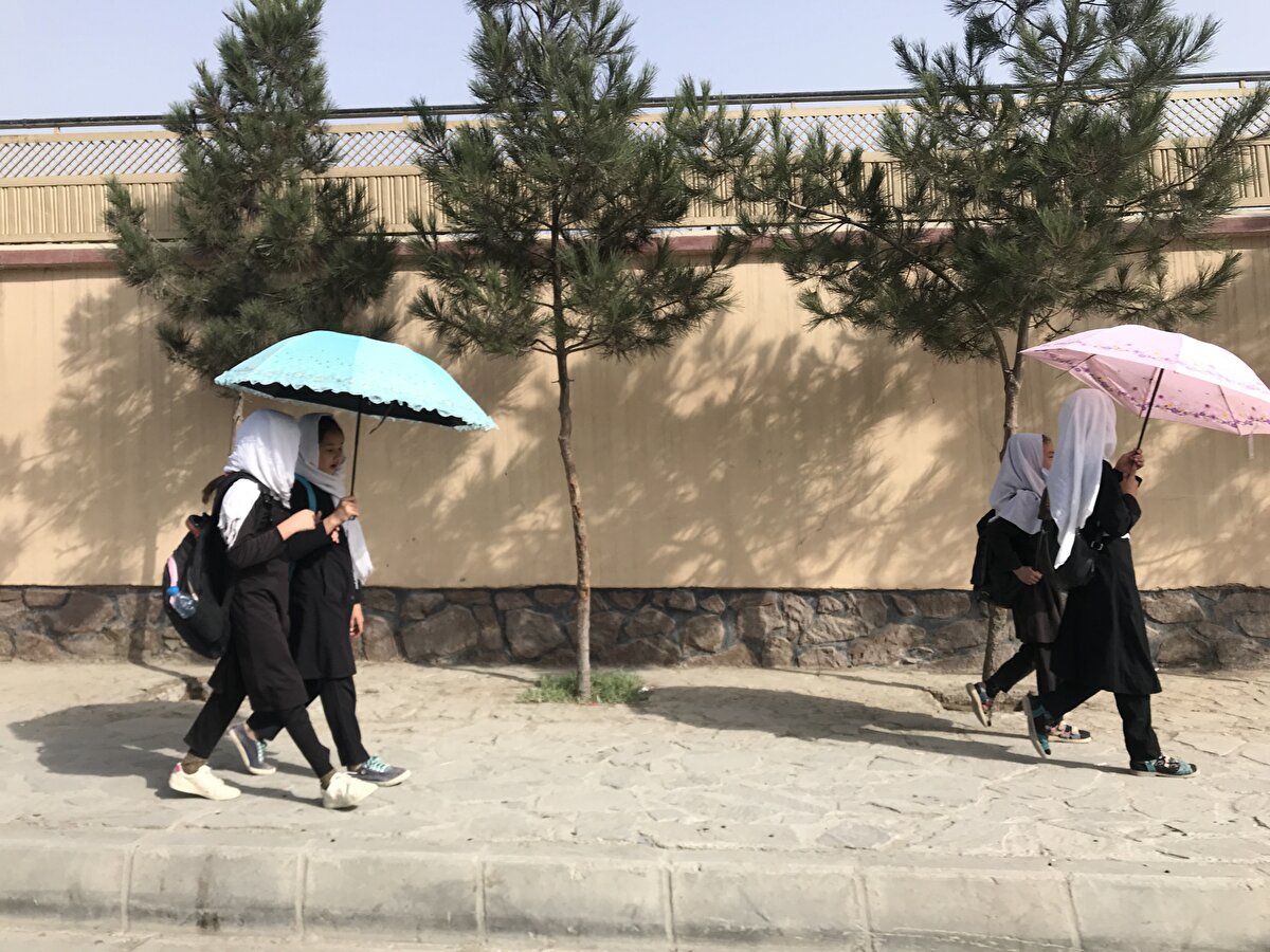 Bölgedeki sıcak hava şartları nedeniyle özellikle kız çocukları ve kadınlar kimi zaman şemsiye kullanmayı tercih ediyorlar. 