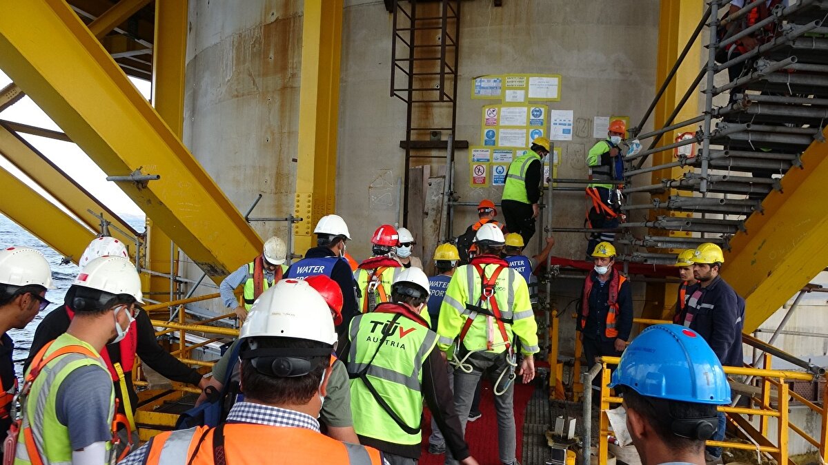 Kule kesonlarının konumlandırıldığı alanda deniz dibi tarama çalışmalarının yapıldığını ifade eden Karaismailoğlu, şunları kaydetti:
"Kule keson temellerinin konumlandırıldığı alandaki deniz tabanında zemin iyileştirmesi için güney kulede 165 adet, kuzey kulede ise 203 adet olmak üzere toplam 368 adet 2,5 metre çapındaki çelik kazık çakıldı. Ana kablo imalatları tamamlanarak, 304 adet tel demetinden oluşan ana kablonun 5 Şubat 2021 tarihinde montaj çalışmalarına başlanılarak, montaj, ön sıkıştırma ve nihai sıkıştırma çalışmaları ile askı kelepçeleri ve düşey askı halatlarının montaj çalışmaları tamamlandı. Tabliye panel ve blok imalatları yapıldı. Montajları tamamlanan 66 adet mega blok, 21 adet single blok, Gölcük Çimtaş Tesisleri'nden Gelibolu Kuru Havuz Bölgesi'ndeki tabliye stok sahasına intikal ettirildi."