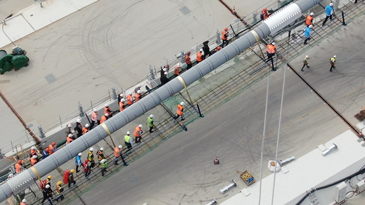 Karaismailoğlu, köprünün 2 bin 23 metre orta açıklık ve 770'er metre yan açıklıklarıyla 3 bin 563 metre uzunluğunda olduğunu belirterek, şunları kaydetti:
"2 bin 23 metrelik orta açıklık, Cumhuriyetimizin 100. kuruluş yıl dönümünü sembolize ediyor ve tamamlandığında dünyanın en büyük orta açıklıklı asma köprüsü unvanına sahip olacak. 365 ve 680 metrelik yaklaşım viyadükleri ile beraber toplam geçiş uzunluğu ise 4 bin 608 metreye ulaşıyor. Köprümüzün 318 metrelik çelik kuleleri, Çanakkale Deniz Zaferi'nin kazanıldığı 18 Mart 1915'i işaret edecektir."
Köprünün iki çelik kule arasında ikiz tabliye olarak tasarlanan nadir asma köprülerden biri olduğunu söyleyen Bakan,"Tamamlanınca, dünyada 2 bin metre orta açıklığın üzerinde ikiz tabliye olarak tasarlanan ve inşa edilen ilk köprü olarak tarihe geçecek. 318 metrelik kule yüksekliği ve 16 metrelik mimari amaçlı top mermisi figürüyle birlikte düşünüldüğünde deniz seviyesinden 334 metre yüksekliğe erişecek ve dünyanın en yüksek kulelerine sahip asma köprüsü olacak" dedi.