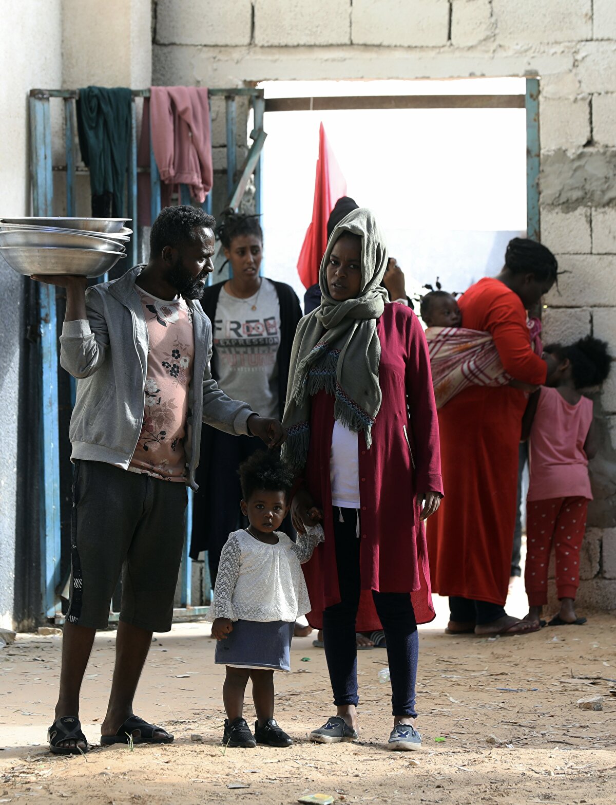 Libya İçişleri Bakanlığı'na bağlı Yasadışı Göçle Mücadele Birimi'nin Trablus'taki göçmen barınma merkezlerinden birinde bulunan göçmenler mevcut durumla ilgili konuştu.<br><br>Trablus'un güneyindeki Ayn Zara Barınma Merkezi, yakın zamanda buraya sevk edilen göçmenlerle birlikte toplam 1277 kişiye "zorunlu ev sahipliği" yapıyor.<br><br>Çoğunluğunu Sudan, Eritre, Etiyopya, Nijerya gibi Afrika ülkelerinden gelenlerin oluşturduğu bu göçmenler arasında 189 kadın ve 69 çocuk da bulunuyor.