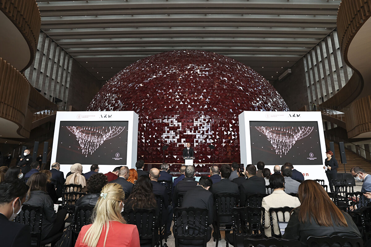 "AKM, 12 Nisan 1969’da İstanbul Kültür Sarayı adıyla hayatımıza girdi. Neredeyse 50 yıllık hizmet süreci içinde elbette yangın ve deprem gibi sıkıntılar yaşadı. Neticede bütün bunlar ciddi yapısal sorunları beraberinde getirdi. Yeni AKM’nin inşa sebebi de bu gereklilikten oluştu. Yaptığımız iş geçmişin emanetine sahip çıkmak ve geleceğe ulaştırmaktır" diyen Ersoy, AKM'nin temel atma töreninin 10 Şubat 2019’da gerçekleştirildiğini anımsattı.<br><br>
