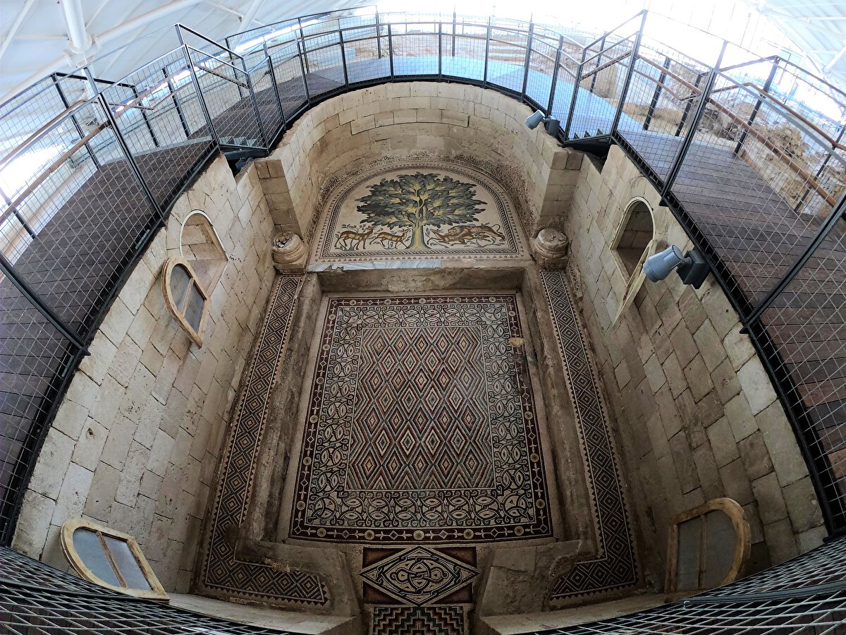 Sarayın banyosunun zemininde yer alan tabloda, bir ağacın etrafında bulunan üç ceylandan birinin aslan tarafından avlanırken, diğer ikisinin ise huzurlu şekilde hayatına devam ettiğini anlatan bir tasvir yer alıyor. Mozaikteki bu tasvirin savaş ve barışı anlattığı belirtiliyor.