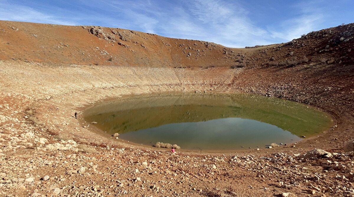 Keban Baraj Gölü'ned balık avına giden Vahdet Gündüz, teknesini  kıyıya demirledikten sonra baraj sularını çekildiğini ve kıyıdan yaklaşık 150 metre içerideki bir tepenin arka kısmında içerisinde su bulunan dev bir çukur olduğunu gördü.<br><br>Gündüz, görünümüyle ilgi uyandıran dev çukurda detaylı tetkik yapılması için durumu Fırat Üniversitesi (FÜ) yetkililerine bildirdi.<br><br>