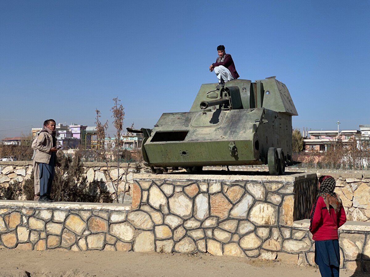 Çocukların oyun bahçesi haline gelen harp kalıntılarının önünde insanlar hatıra fotoğrafı çektiriyor.