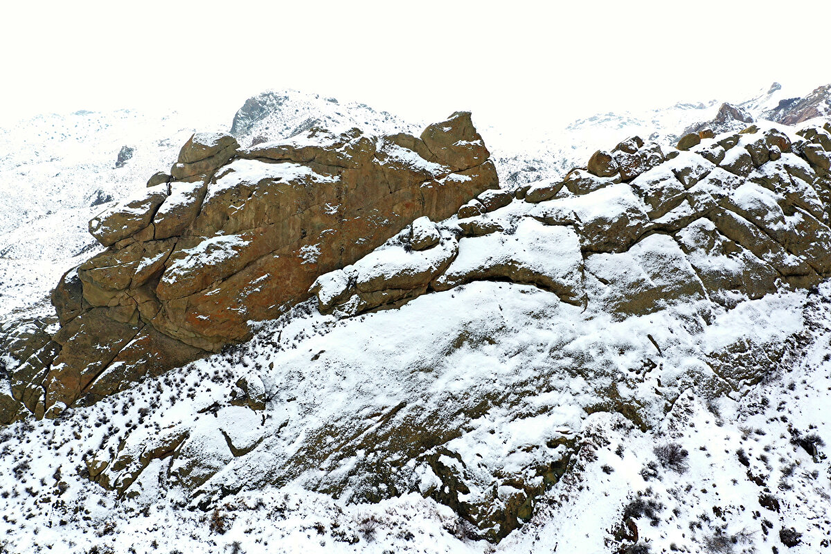 Bir akarsuyun kenarlarında, onlarca metre yüksekliklere ulaşan dik kayaların bölgedeki kar yağışının ardından beyaz örtüyle kaplanması, güzel görüntüler oluşturdu.