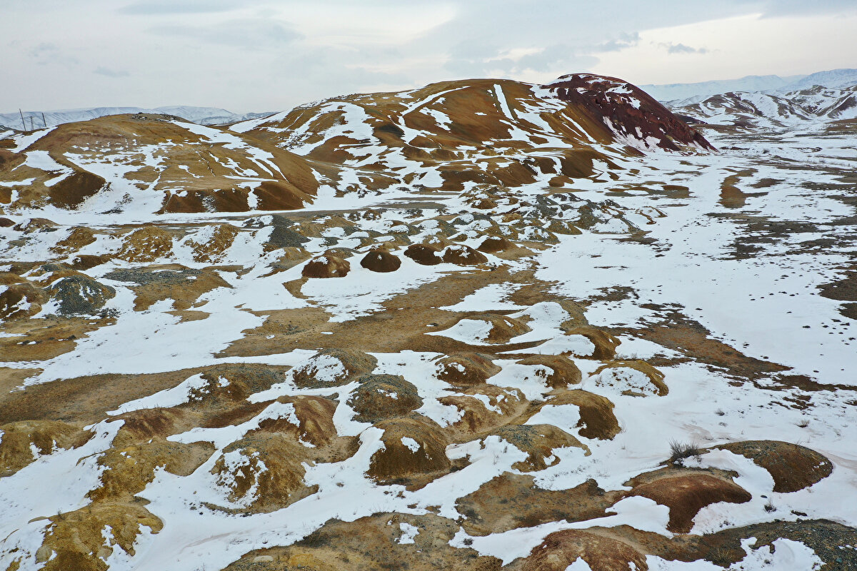 Tuzluca ilçesinin batısındaki tepeler, kırmızı, kahverengi, boz ve sarı tonlarının yer aldığı görüntüsüyle ilgi çekiyor.