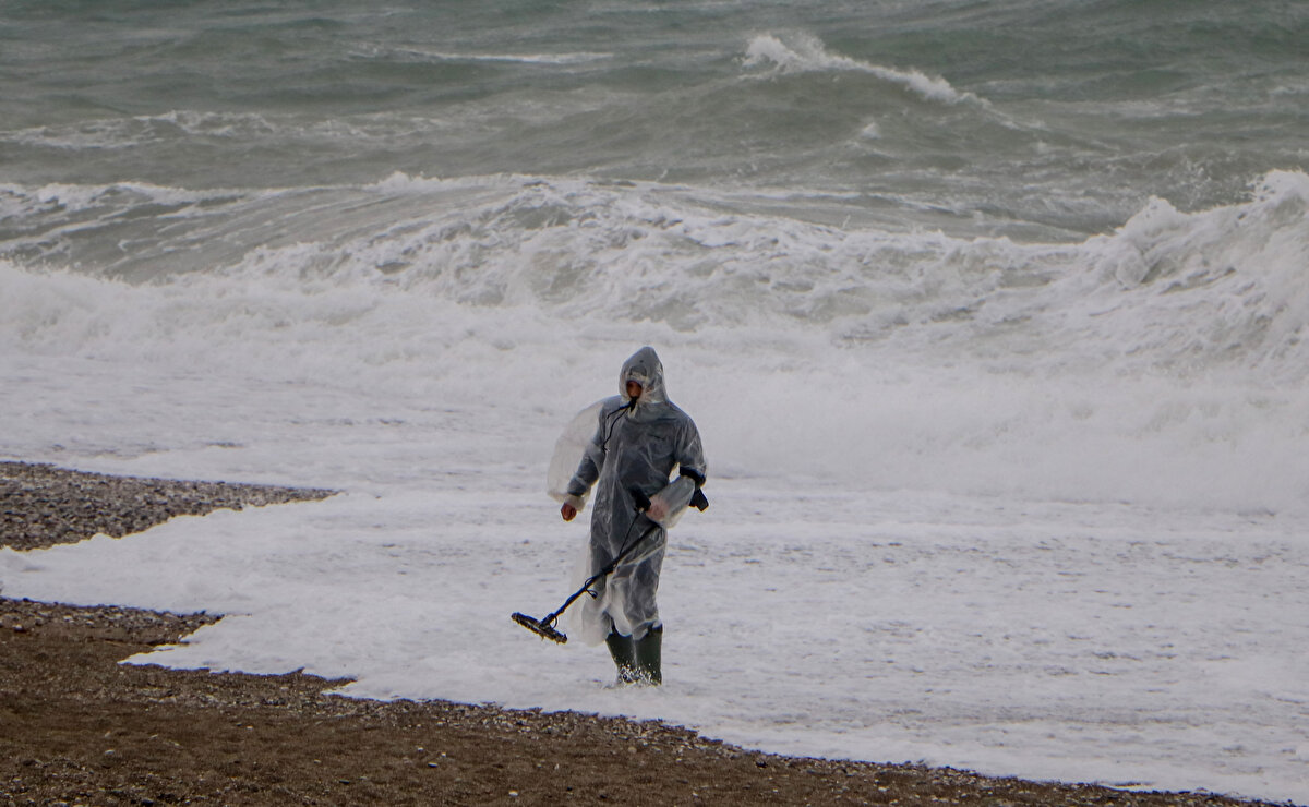 Dalgalara ve fırtınaya aldırış etmeyen bu kişiler, dedektörle dalgaların getirebileceği altın, gümüş ve madeni paraları aradı.<br>