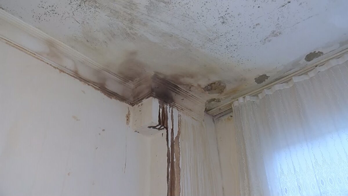 "MUTFAK TAVANI NAYLONLA KAPLI"<br>Banyo tavanından demirler gözüken, mutfak tavanının naylon ile kapatan ve odasının bir tanesi komple rutubet saran evde 18 yıldır yaşayan Suna Erşahin de, "Bu çökmeler son 5 senedir var. Üstümdeki dairenin bütün demirleri çıktı ve onun suyu bana geliyor. Mutfak tavanını naylonla kapattık, diğer yerlere leğen koyuyoruz. Banyonun tavanı hep düşük. Belediye bu duruma el atsın. Ev tutup çıkabilsem çoktan çıkmıştım. Diğer ailelerin hepsi gitti biz 5 kişi kaldık. Hepsini kiraya verdiler" diye konuştu.