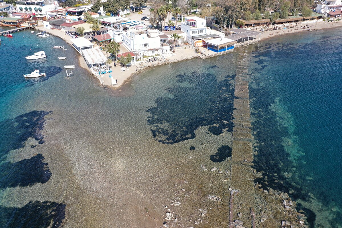 Türkiye'nin tarihi ve doğal güzellikleriyle bilinen Bodrum'un Gümüşlük Mahallesi'nde yılda birkaç kez tekrarlanan doğa olayı, deniz altındaki tarihi gün yüzüne çıkarıyor.