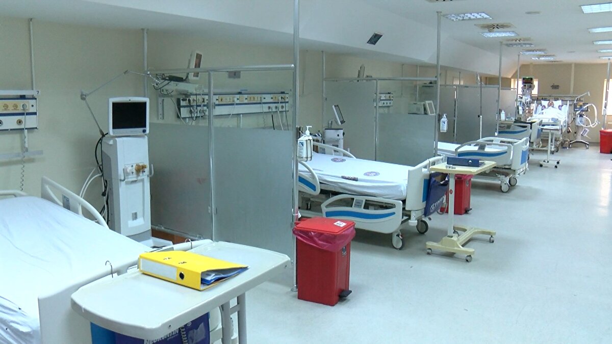 Biz de diğer hastanelerde olduğu gibi bir bölümümüzü COVID dışı hastalara, bir bölümü de COVID hastalarına ayırmıştık. COVID dışı yoğun bakımımız yüzde 100 oranında doluluğa ulaştı. İhtiyacı olan hastalarımızı normal yoğun bakıma alabilmek için de COVID azalmasından da yararlanarak tekrar bu ünitemizi de normal yoğun bakıma çeviriyoruz. Şu anda bu boş gördüğünüz yataklar, bugün itibarıyla diğer hastalarla dolacak. Şu anda (ameliyat için) sırada bekleyen 8 hastamız, biraz sonra bu yataklara gelmiş olacak. COVID için ise daha küçük bir yoğun bakım ünitesini aktif tutacağız. Hastalar oldukça, orada bakmaya devam edeceğiz. Çok ilerlememiş kanser hastaları beklemeye alınmıştı pandemi döneminde. Şimdi onların operasyonları gerçekleşecek. Ayrıca çeşitli yandaş hastalıkları olan ve ameliyat sonrası yoğun bakım ihtiyacı doğabilecek kritik durumdaki hastalar var. Pandemi hastaları bitmeye başladıkça, travma hastaları, kafa travmaları, trafik kazası, yaygın vücut travmaları gibi hastalar artmaya başladı. Pandemide yoğun bakımda olmayan bu hastaları tekrar yatırmaya başladık.