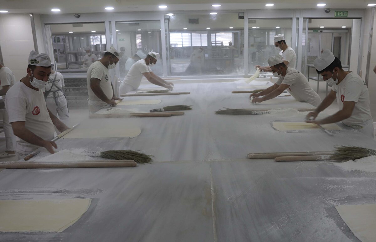 Baklava ustaları, ramazan ayında artan talep dolayısıyla yurt içinden ve dışından gelen siparişleri yetiştirmek için humma çalışmalarını sürdürüyor.<br>