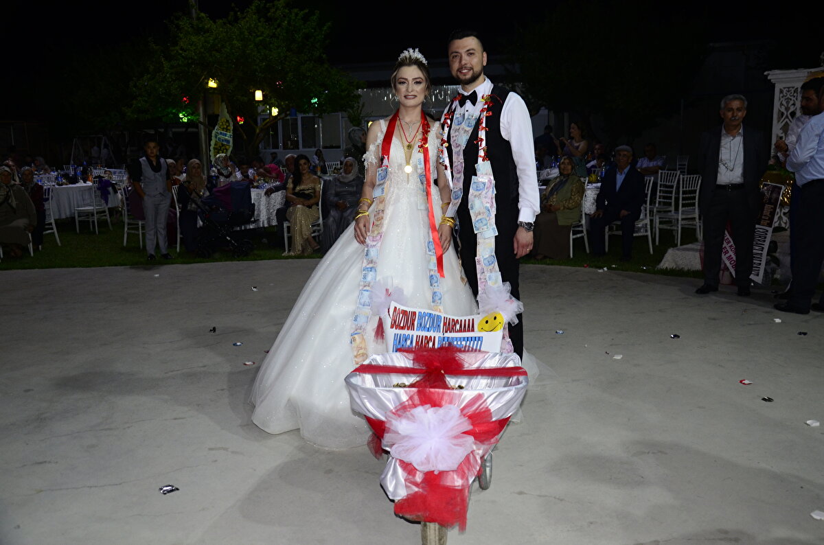 "İNTİKAMIMI ALDIM"<br>Arkadaşlardan Necati Kaman da geçen yıl kendisine yapılan eziyeti anımsatarak, şunları kaydetti:<br><br>"Daha önce Cihan kardeşimiz bana 60 metre uzunluğunda beşlik banknot takmıştı. Bugün de ondan intikamımı aldım. Birlik şeklinde ve elli kuruş şeklinde dört arkadaşımız toplamda 6 bin 200 lira para topladık. Bunu el arabasıyla getirdik. Yaklaşık 55 kilo yapıyor hepsi. Çuvallarda getirerek el arabasının içine döktük. Esnaftan 3 günde topladık."<br><br>Çuvallardaki madeni paraların el arabasına boşaltılmasının ardından damat Eroğlu, el arabası ile salonda tur attı.