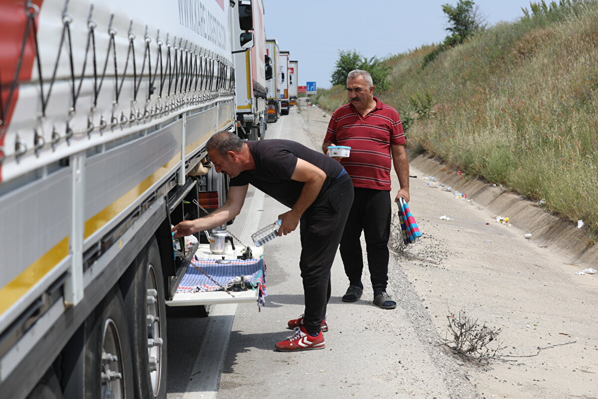 "HİÇ BÖYLE BİR SIRAYA DENK GELMEDİM"<br>TIR sürücüleri bir haftadır ışırı sıcak altında beklemelerinin tesis yokluğu nedeniyle çileye dönüştüğünü dile getirdi.<br><br>Meslek hayatı boyunca bu denli uzun kuyruğa denk gelmediğini söyleyen sürücü Mustafa Öztürk, "Bu 1 aydır sürüyor. Hiç umursamıyorlar. Bizden para kazanıyorlar ama nedense bizi düşünerek hareket etmiyorlar. 1 arabayı 15 dakikada kontrol ediyorlar. Bulgaristan'ı geçmek 2-2,5 saati buluyor" dedi.