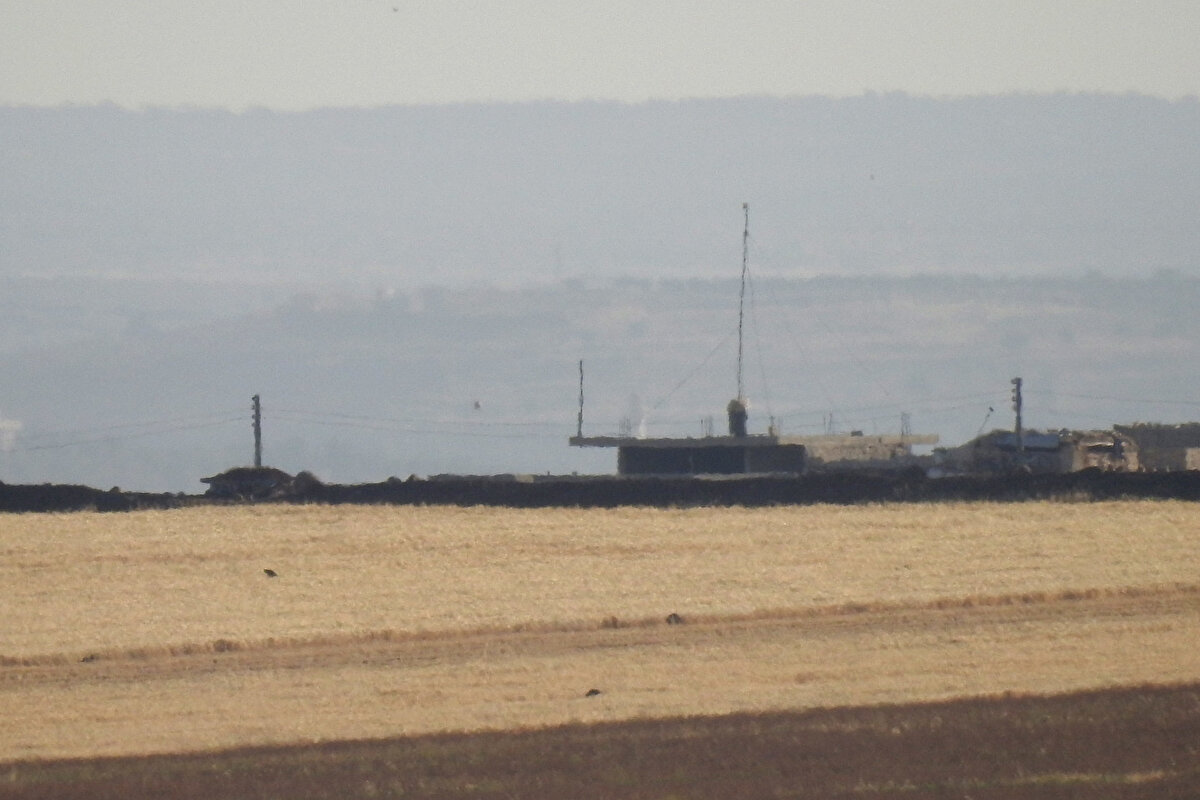 Fırat Kalkanı bölgesindeki cephe hattından yapılan çekimde, Tel Rıfat merkezinin tam ortasındaki büyük anten kulesinde rejim bayrağının asılı olduğu görülüyor.