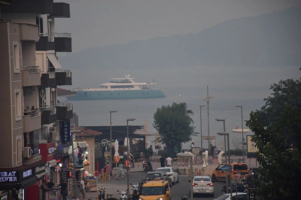 Bördübet mevkisindeki yangının duman ve külleri rüzgarın etkisiyle ilçe merkezine kadar geldi.<br><br>Körfez ve karada duman etkili olurken cadde ve sokaklarda küller birikti.<br><br>
