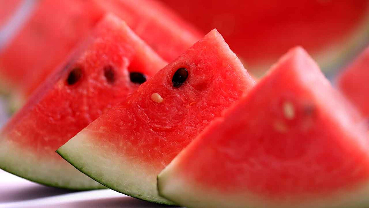 KARPUZ SUYUNU TERCİH ETMEYİN<br><br><br>Glisemik indeksi yüksek olan, dolayısıyla fazla miktarda yenildiğinde kan şekerini hızla yükseltme riski taşıyan karpuz, meyve suyu veya smoothie şeklinde tüketildiğinde kan şekerinin düzenlenmesinde sorun oluşturabiliyor. Bunun nedeni ise karpuz suyu olarak tüketildiğinde karpuzun porsiyon miktarının artması. Smoothie’lerde de hem ekstra başka besinlerin eklenmesi hem de yine bir sıkma işlemi uygulandığı için porsiyon miktarı, dolayısıyla kalori içeriği artıyor. Beslenme ve Diyet Uzmanı Ezgi Hazal Çelik, “Meyve suyunda C vitamini ve lifin büyük bir kısmının kaybolduğunu da göz önünde bulundurarak, karpuzu meyve şeklinde tüketmeniz daha sağlıklı olacaktır” diyor. 