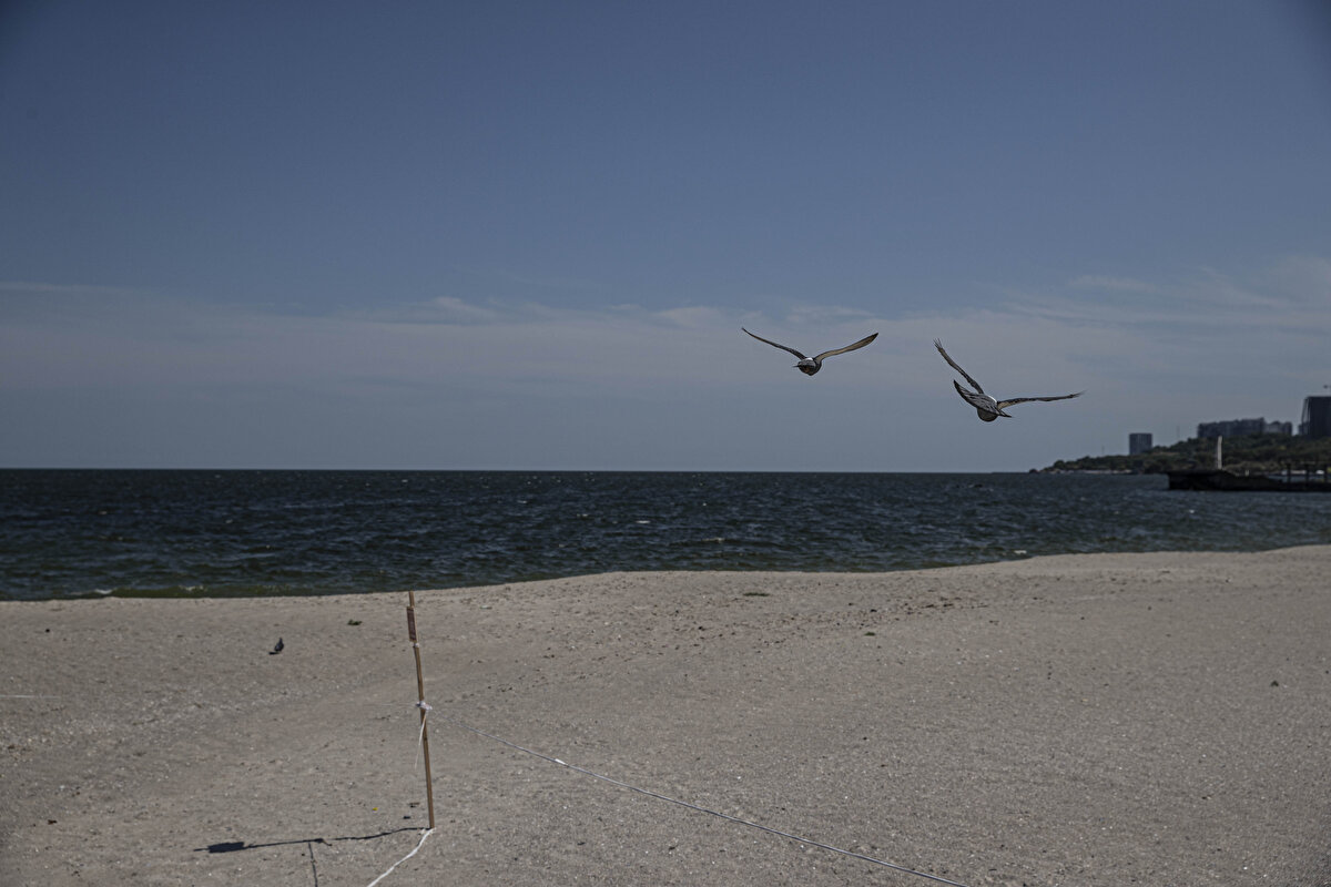 Nüfusu bir milyonu aşkın olan ve Ukrayna'da "Karadeniz'in incisi" olarak bilinen kentte deniz sezonu başlamış olsa da denize girişi yasaklayan emniyet şeridi mayın tehlikesini işaret ediyor.<br>