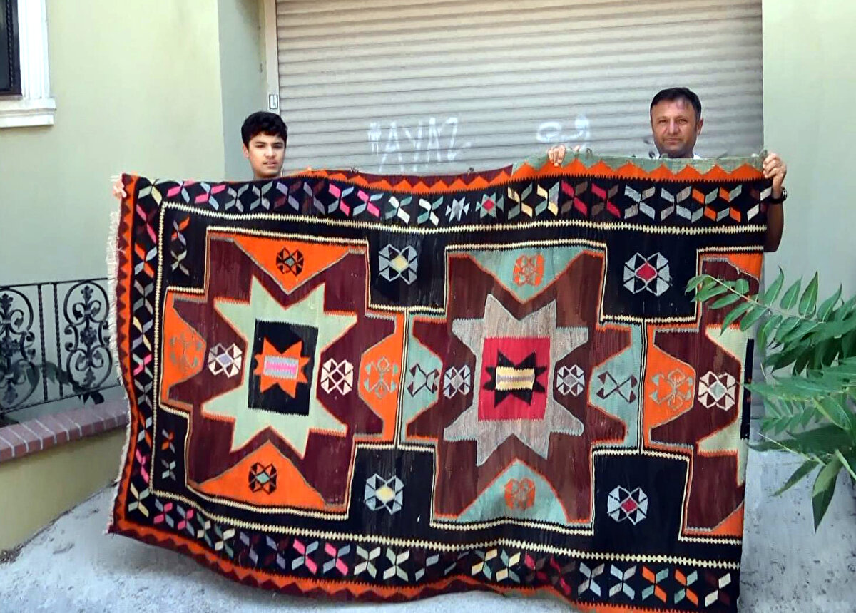 Cennet Mahallesi'nde oturan Ercan Dede, 3 gün önce birinci kattaki balkon demirine kök boyadan yapılan 100 yıllık olduğu belirtilen halıyı astı. 