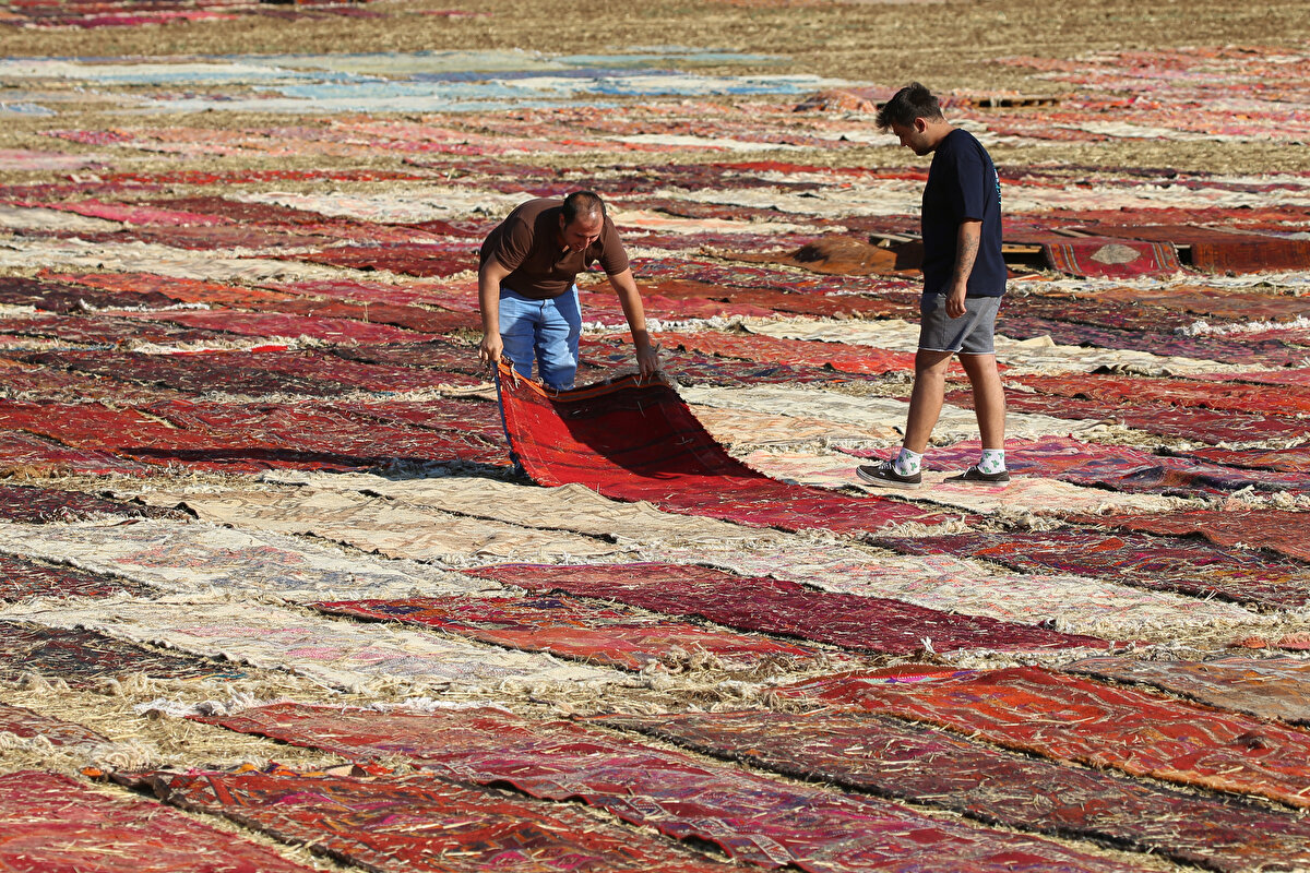 Yağışlı havalarda depolara kaldırılan el dokuması halı ve kilimler, güneşin kendisini göstermesiyle yeniden tarlalardaki yerini alıyor. Zaman zaman rüzgar nedeniyle ters dönen, kıvrılan halılar hemen düzeltiliyor, belli aralıklarla da tozlarından arındırılıyor.<br>