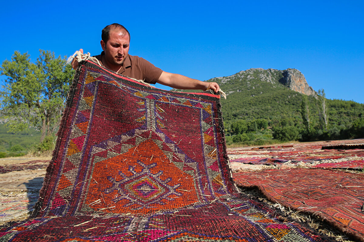 Bitkilerden elde edilen kök boyası kullanılarak orijinal tezgahlarda dokunan el halılarıyla ünlü Döşemealtı ilçesindeki hasadı tamamlanan tarım arazilerinde, yaz aylarında farklı bir hareketlilik yaşanıyor.<br>