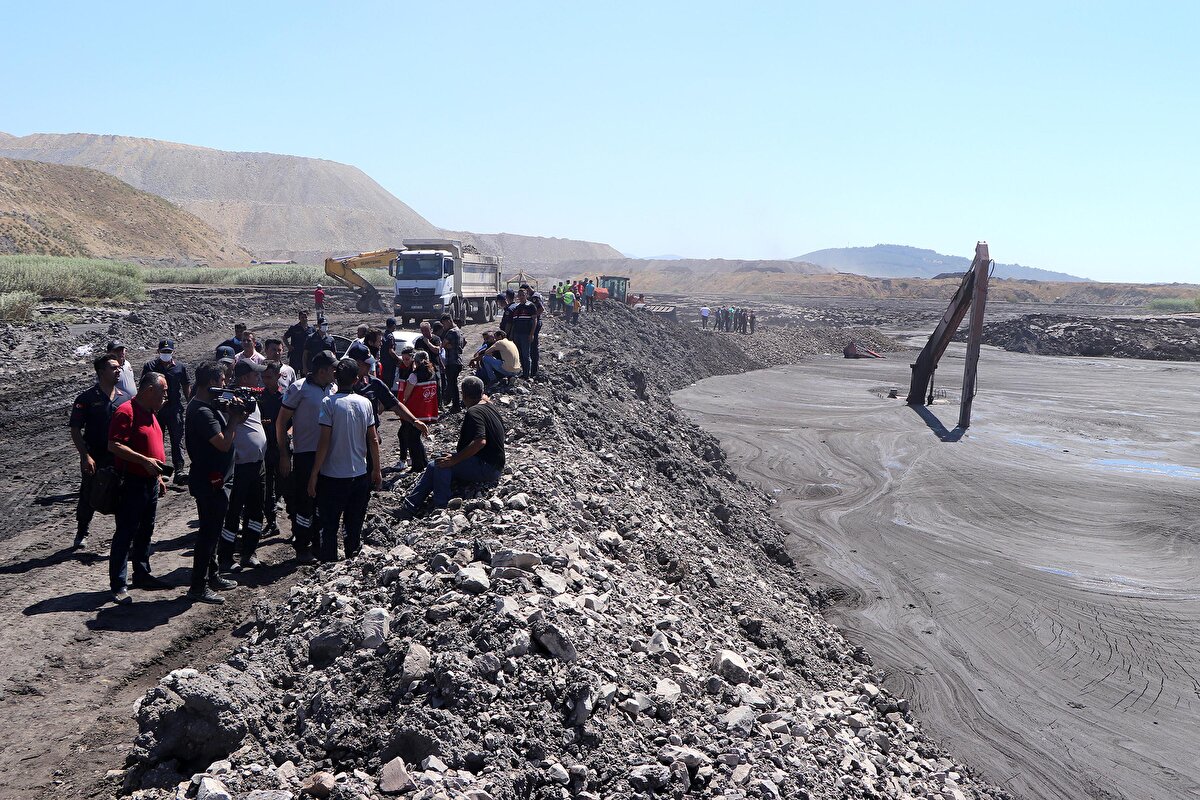 Ekipler dozerler ile kepçeyi çekmeye çalışırken, diğer yandan havuzdaki çamuru tahliye işlemi sürüyor.<br>