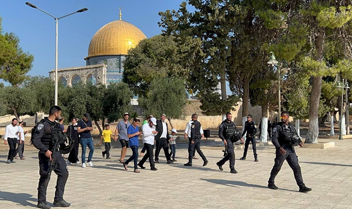 Sabah saatlerinde Mescid-i Aksa`ya giren İsrail polisi, avluda bulunan Müslümanları zor kullanarak buradan uzaklaştırdı. İsrail polisi, Mescid-i Aksa`nın kapılarında demir barikatlar kurarak Müslümanların girişini engelledi. İsrail polisinin eşliğinde Yahudi yerleşimciler gruplar halinde Mağaribe Kapısı`ndan Mescid-i Aksa`ya baskın düzenledi.Sosyal medyada paylaşılan görüntülerde, bazı Yahudi yerleşimciler, Aksa içinde yere yatarak dini ritüellerini yerine getiriyor. Kudüs İslami Vakıflar İdaresi, sabah saatlerinden itibaren Mescid-i Aksa`ya baskın düzenleyen Yahudi yerleşimci sayısının 1000`e ulaştığını paylaştı.<br><br>