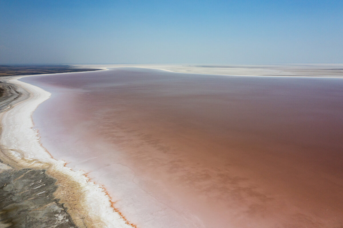 BEYAZ VE PEMBE BİR ARADA<br><br>Algler, sıcaklığın ve tuzluluğun arttığı yaz dönemlerinde kırmızı renkli beta-karoten madde üreterek güneş ışınlarının zararlı etkilerinden kendisini koruyor. Yine bu dönemde halo bakteriler ise fazla ürediği için gölün rengi pembe veya kırmızı renge bürünüyor. Sıcaklık azalınca veya yağmurlu dönem başlayınca göl tekrar eski haline kavuşuyor.