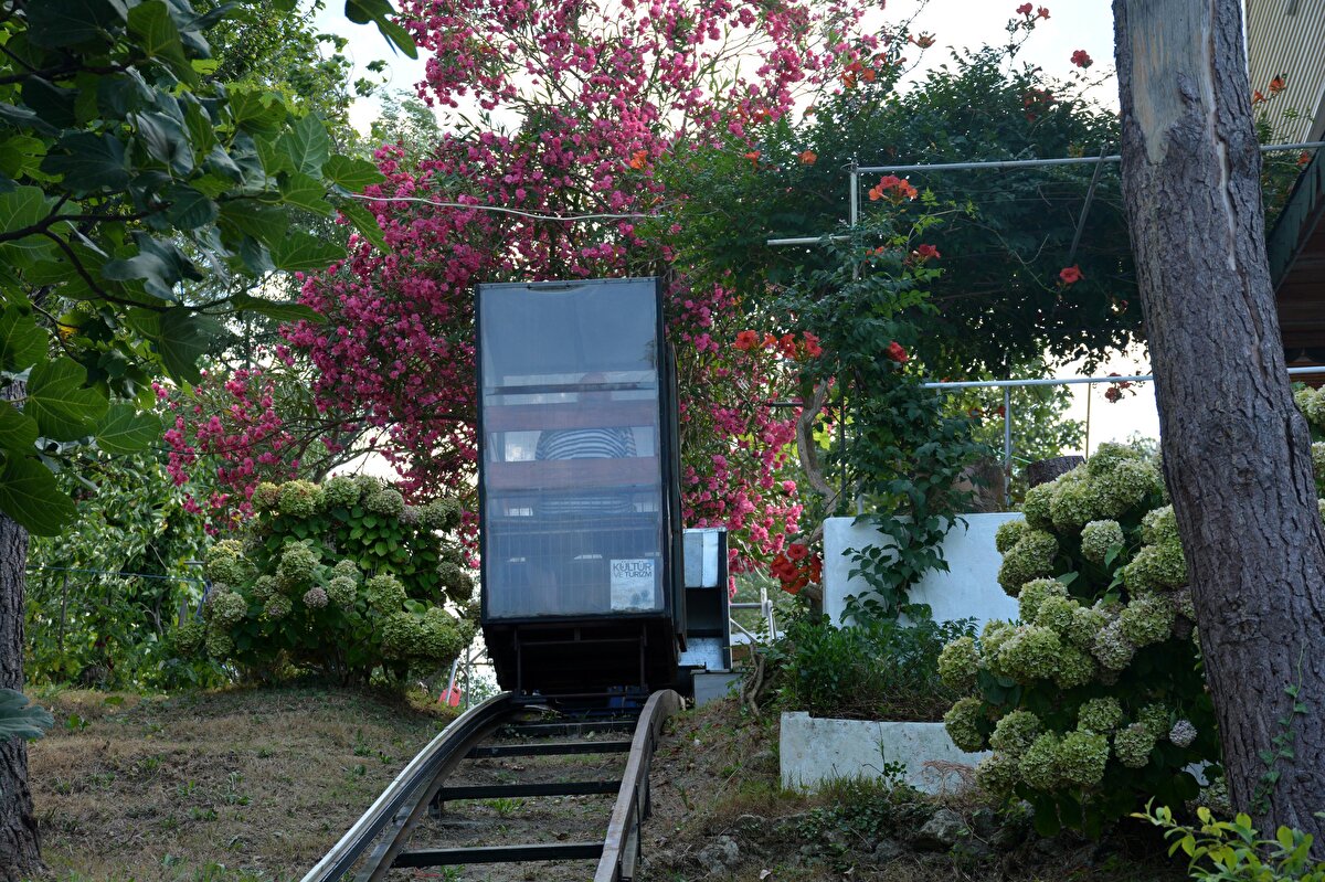 Demirkol, eğimli araziden geçerek 1 dakikalık yolculukla tepedeki evine inip çıkıyor. Yük de taşınabilen raylı sistemi eve gelen misafirler de kullanıyor.