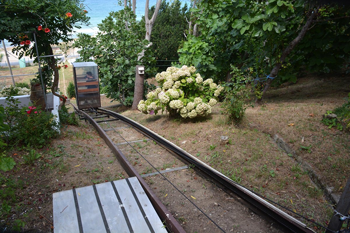 Bostancılı Mahallesi'nde yaşayan ve yürüme güçlüğü çeken Asım Demirkol, yıllar önce sarp arazisine inşa ettiği evine merdivenlerden rahatça inip çıkamayınca ilginç bir çözüm yolu buldu. 