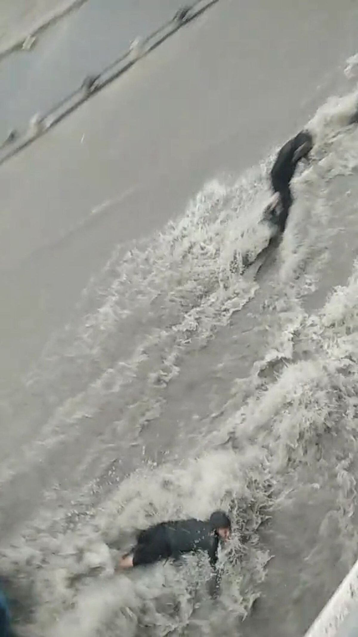 Pınar Mahallesi'nde dereye dönen yokuşta, 1'i çocuk 2 kişi yolun karşısına geçmeye çalışırken, akıntıya kapıldı.