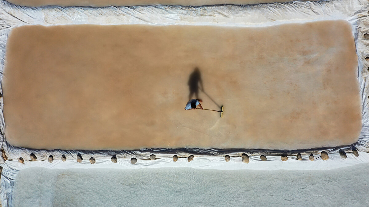 Köylerinin 200 yıllık tarihe sahip olduğunu anlatan Atmeca, şunları kaydetti:<br><br>"Atalarımız bu kuyulardan yararlandı. Biz de kaynakları gördükten sonra farklı kaynaklar elde etmeye çalıştık. Çıkan suyu 4 metrelik kuyulara aktarıyoruz. Bu kuyularda bir hafta dinlendiriyoruz, tuzluluk oranının daha fazla olması için. Ardından havuzlara aktarıyoruz. Bir hafta bekledikten sonra buharlaşan suyun içinde tuz dibe çöküyor ve tuzu çıkarıyoruz. Kuruması için 2 gün bekletiyoruz ve ardından çuvallara dolduruyoruz."<br><br>Bazılarının tuzu makinede öğüttüğünü anlatan Atmeca, "Biz öğütmüyoruz çünkü halk kaya tuzunu bu şekilde tercih ediyor." diye konuştu.